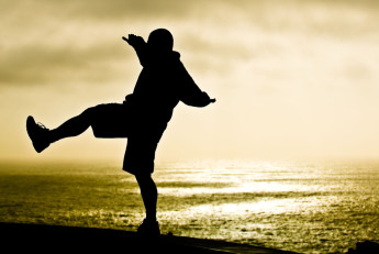 Shadow of a Man Balancing on One Foot by the Ocean