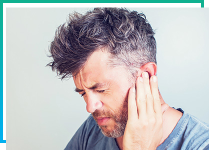 man holding his ear in pain